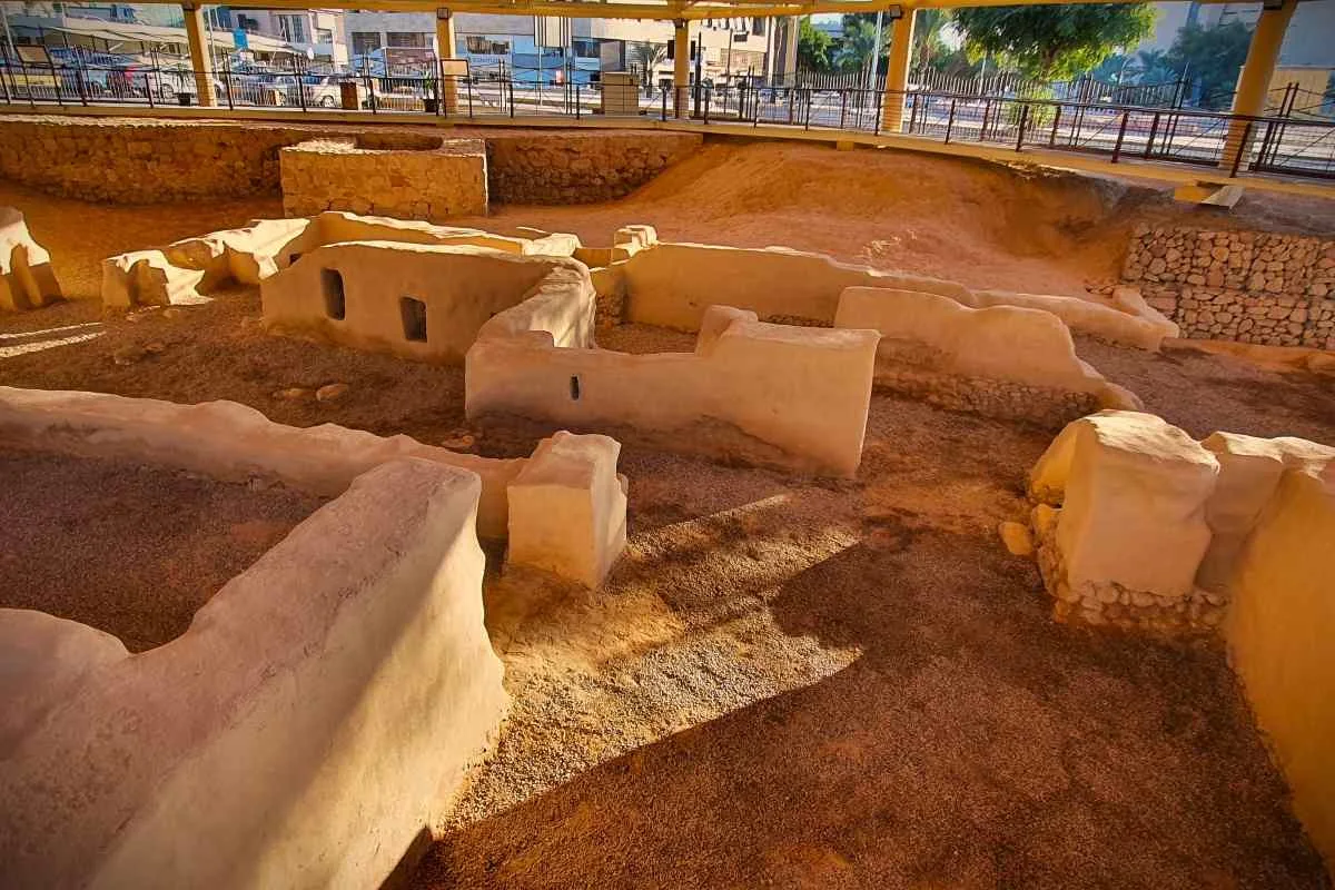 Aqaba Church — Reading the space View across preserved earth-coloured church walls with railings beyond